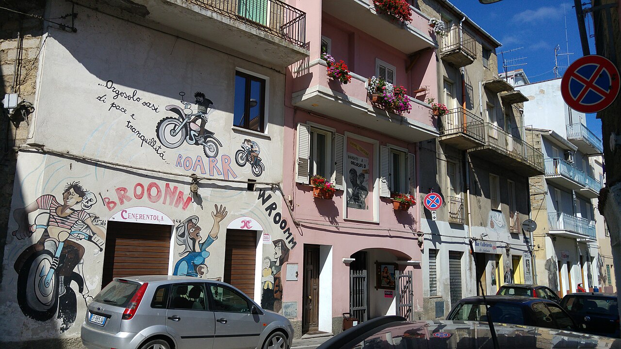 Via di Orgosolo con murales sulle facciate delle case