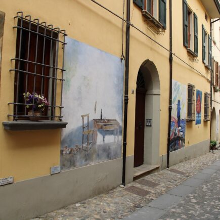 Vicolo di Dozza, in provincia di Bologna, con murales dipinti sulle facciate delle case