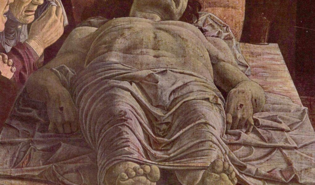 Cristo morto di Andrea Mantegna: il corpo di Cristo disteso in scorcio sulla pietra, con i piedi verso chi guarda e tre dolenti a sinistra